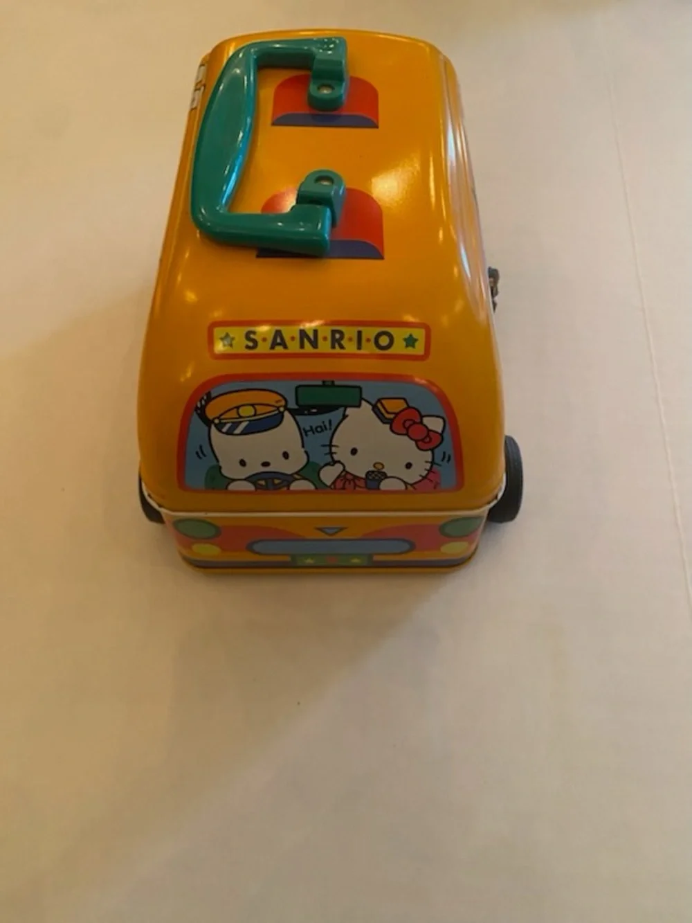 A Sanrio Yellow Toy Bus Metal Carry Case with Teal Handle
